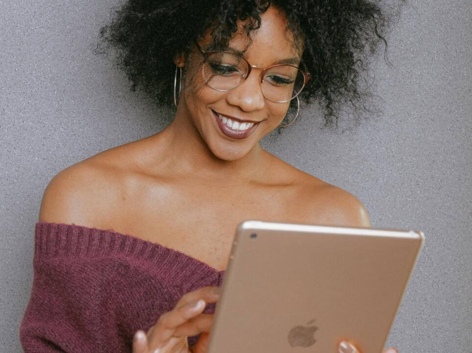 woman in purple off shoulder top holding an iPad