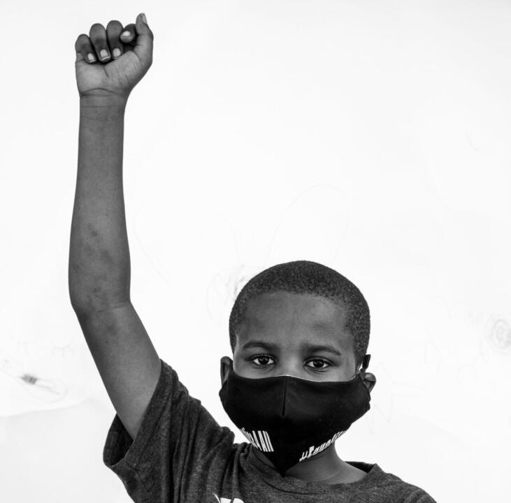 young boy holding fist in the air for the black lives movement
